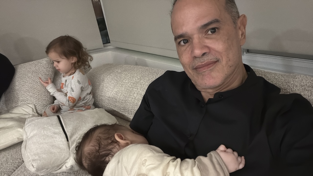 Saulo with both grandchildren on the couch at night