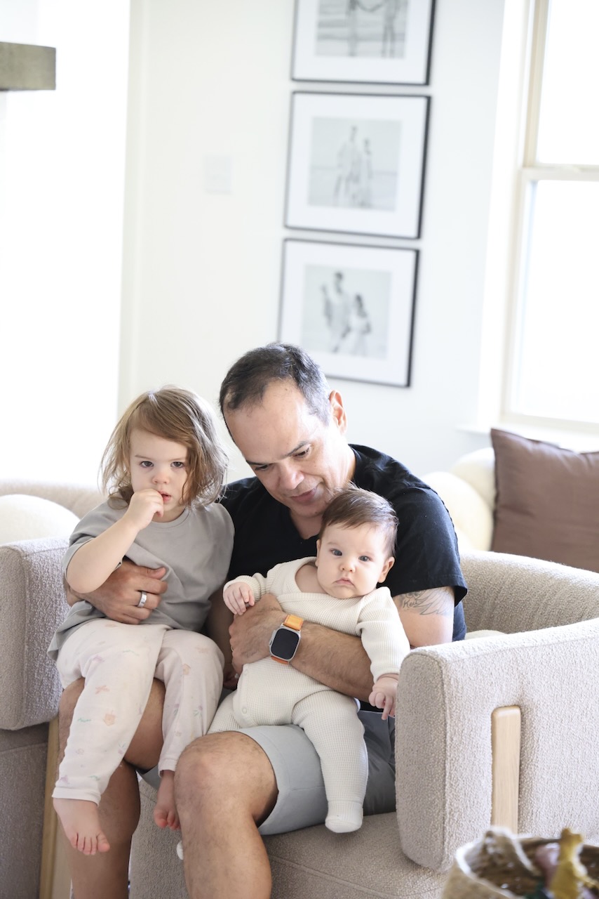 Saulo with his two grandchildren on the couch