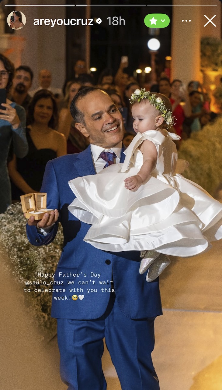 Saulo in blue suit carrying his granddaughter Emma